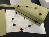 Van Cleef & Arpels necklace with clover designs on a green cushion, accompanied by a certificate of authenticity.