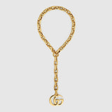 Gold chain bracelet with Gucci logo on a light gray background