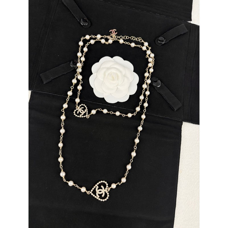 Pearl necklace with a white flower brooch on a black outfit