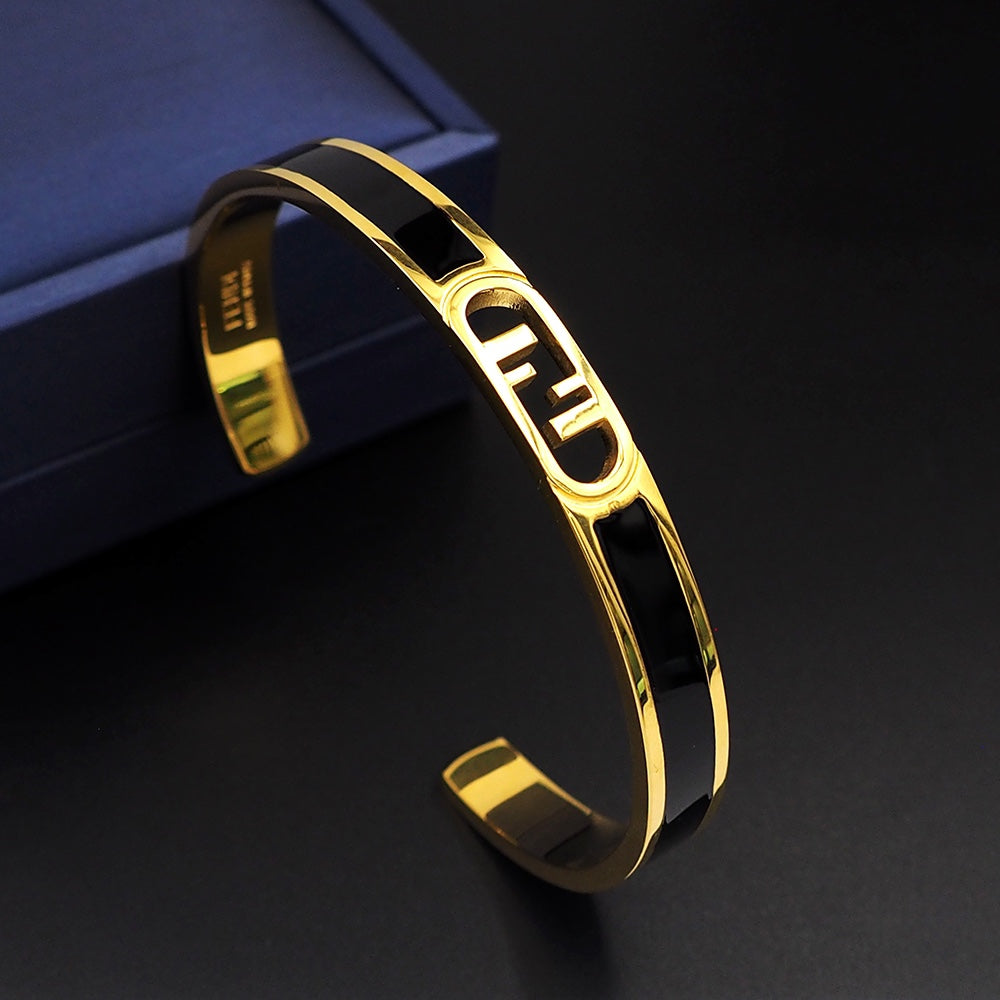 Gold bracelet on a dark surface with a blue box in the background