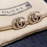 Gold Gucci earrings on a Gucci branded pouch